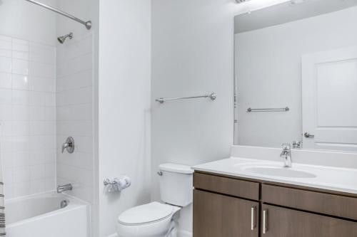 a white bathroom with a toilet and a sink at Assembly Row 1BR w Gym WD nr Assembly T stop BOS-625 in Somerville