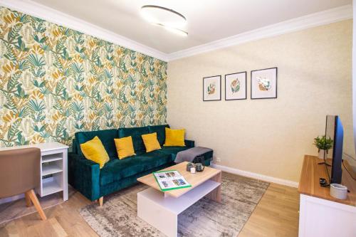a living room with a green couch and a table at Hillside Lodge in Budapest