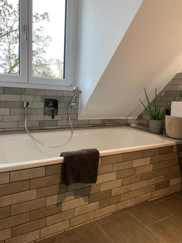 uma casa de banho com banheira e mangueira em Anderswo Apartments em Langenau