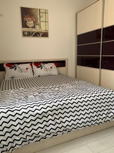 a bedroom with a bed with a black and white comforter at Luxury apartament in Dudu