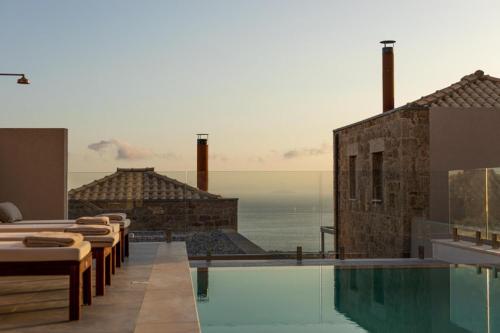 a hotel with a swimming pool with a view of the ocean at Patio Villas Complex in Stoupa