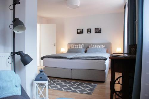 a bedroom with a bed and a desk with two lamps at LUX Ferienwohnung im Weinort Pommern an der Mosel in Pommern