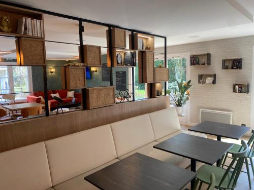 a dining room with two tables and a couch at Campanile Nantes ~ Rezé Aéroport in Rezé