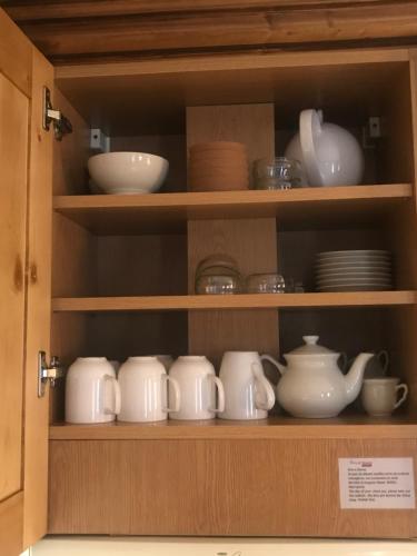 une armoire remplie de plats, de bols et de assiettes dans l'établissement La Ginabelle Gala, à Chamonix-Mont-Blanc