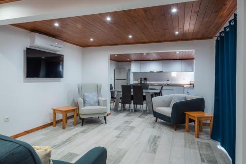 a living room with chairs and a table and a kitchen at Tranquilidade in Estreito da Calheta
