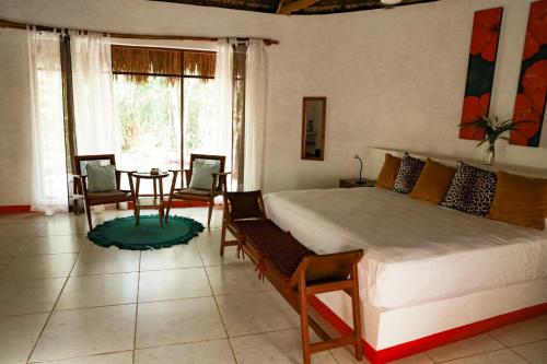 um quarto com uma cama grande, uma mesa e cadeiras em Hotel B. Secreto Maya em Yaxché