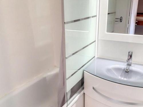 une salle de bain blanche avec un lavabo et un miroir dans l'établissement Studio cabine climatisé avec piscine et parking à Bormes-les-Mimosas - FR-1-610-75, à Bormes-les-Mimosas