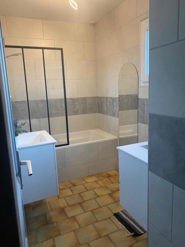 a bathroom with a tub and a sink at La clé des champs in Acheux-en-Vimeu