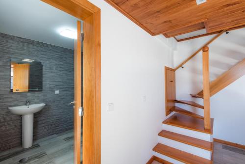 a bathroom with a sink and a stairway with a stairwayexit at Tranquilidade in Estreito da Calheta