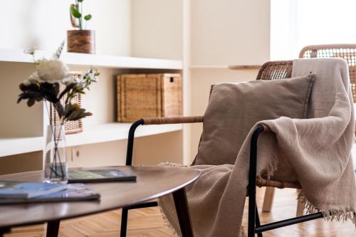 a living room with a table and a chair at Unirii Center Apartments by Olala Homes in Bucharest