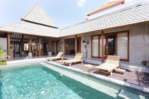 a villa with a swimming pool and a house at Kano Canggu in Canggu