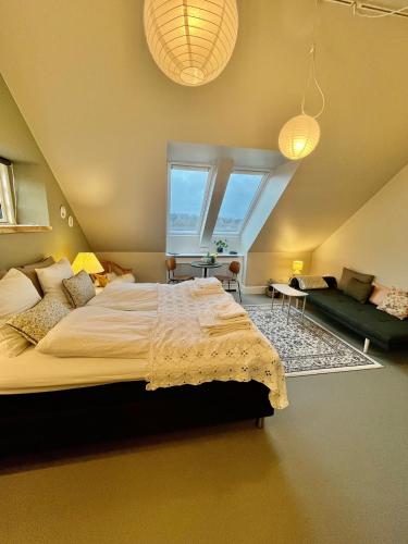 Un dormitorio con una cama grande y un sofá. en GaestFri Overnatning, en Gjern