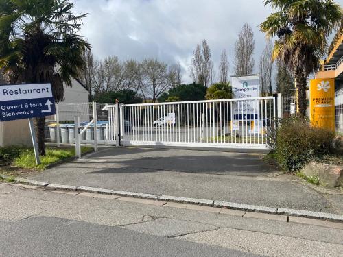 a white gate on a street with a sign at Campanile Nantes ~ Rezé Aéroport in Rezé