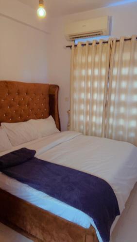 a bedroom with a large bed and a window at Exquisite 2-Bedroom Apt in Oniru in Lagos