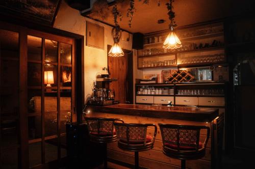 a bar with chairs and lights in a room at 歩絵夢の森 Pension Poem no mori in Hakuba