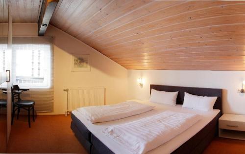 a bedroom with a large bed with a wooden ceiling at Am Schmuggerbühl in Bodenmais