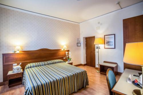 Habitación de hotel con cama y escritorio en Hotel Martelli, en Florencia