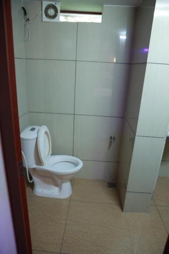 a bathroom with a toilet with the lid up at SpiceBuds FarmStay - Ramakkalmedu in Idukki