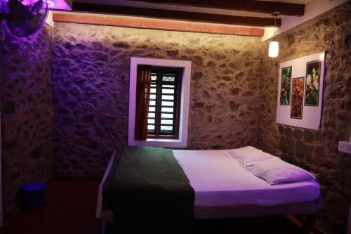 a bedroom with a bed in a room with a window at SpiceBuds FarmStay - Ramakkalmedu in Idukki