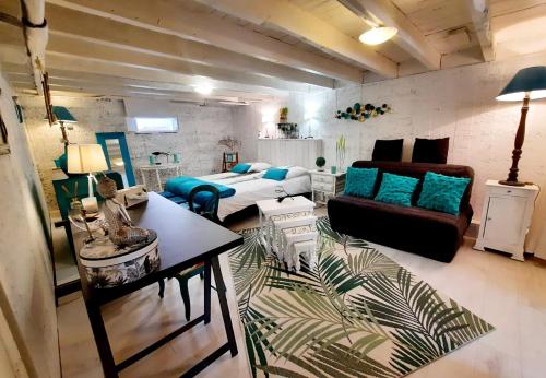 ein Wohnzimmer mit einem Bett und einem Sofa in der Unterkunft Le Petit Nicol in Bergerac