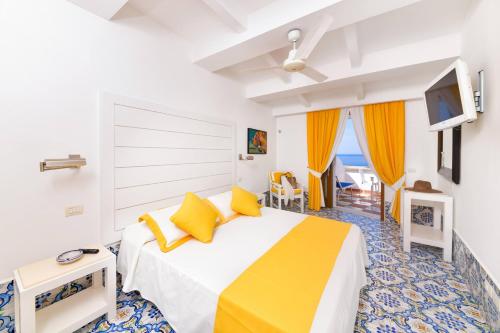 a bedroom with a large bed with yellow pillows at Hotel Casa Celestino in Ischia