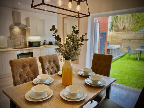 a dining room table with a vase of flowers on it at Family modern 3 Bed Hot Tub House in Blackpool in Blackpool