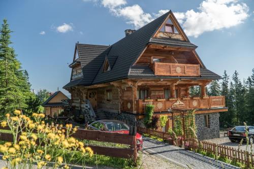 a large wooden house with a black roof at Bukowiańska Ostoja Jacuzzi Sauna i Balia w Ofercie, 60m od Wyciągów in Bukowina Tatrzańska