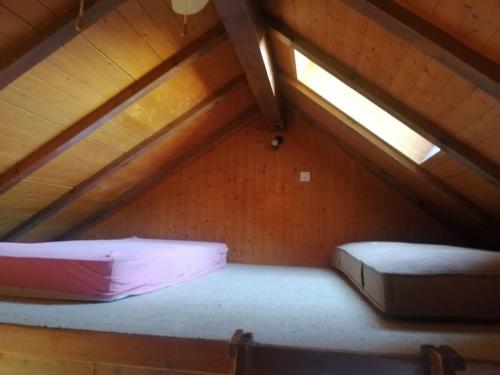 a attic with two beds and a skylight at Le Raccard de Turin VS in Salins