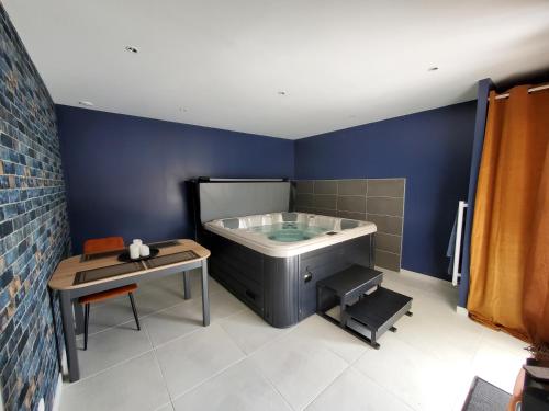 a bathroom with a bath tub and a table at Hortensia, Gîte famille et amis in Fontenay-le-Comte