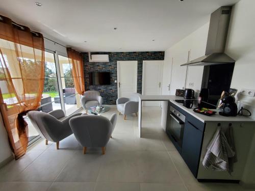 une cuisine et un salon avec une table et des chaises dans l'établissement Hortensia, Gîte famille et amis, à Fontenay-le-Comte