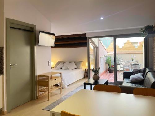 a bedroom with a bed and a living room with a couch at SF Apartamento céntrico con terraza in Terrassa