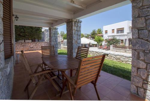 a wooden table and chairs on a patio at Malvazios Villas #4 in Gythio