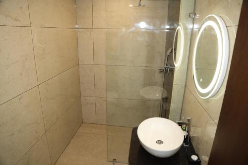 a bathroom with a sink and a shower with a mirror at The Zen Park Coimbatore in Coimbatore