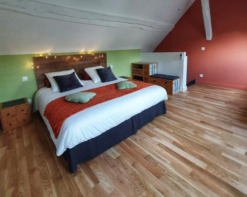 a bedroom with a large bed with red and green walls at LARBRENVILLE Gîtes citadins en centre-ville historique in La Charité-sur-Loire