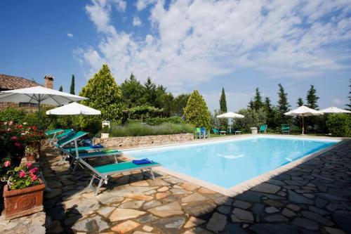 een zwembad met ligstoelen en parasols bij Il Melo in Castellina in Chianti