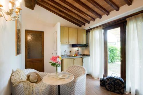 een woonkamer met een tafel en stoelen en een keuken bij Il Melo in Castellina in Chianti