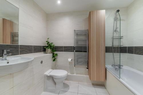 a bathroom with a toilet and a sink and a tub at Luxury 2 Bedroom Large Balcony 5 Minutes to Kensington, Holland Park, Westfield Shopping Centre, Portobello Market in London