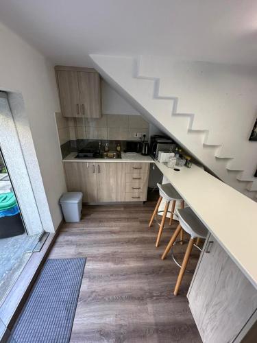 a kitchen with a staircase and a counter with chairs at Modern City Center Appartment Saripolou in Limassol