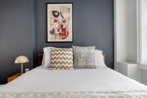 ein Schlafzimmer mit einem weißen Bett und einer blauen Wand in der Unterkunft Downtown 1BR w WD in-unit nr TD Garden BOS-212 in Boston
