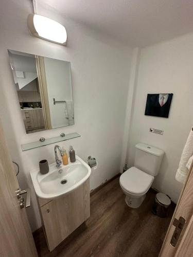 a bathroom with a sink and a toilet and a mirror at Modern City Center Appartment Saripolou in Limassol