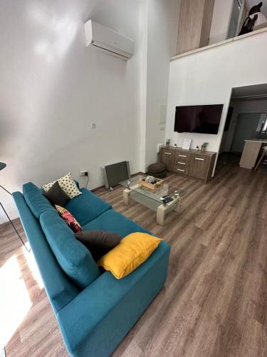 a living room with a blue couch and a tv at Modern City Center Appartment Saripolou in Limassol