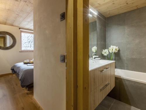 a bathroom with a sink and a tub next to a bed at Chalet La Clusaz, 8 pièces, 13 personnes - FR-1-304-177 in La Clusaz
