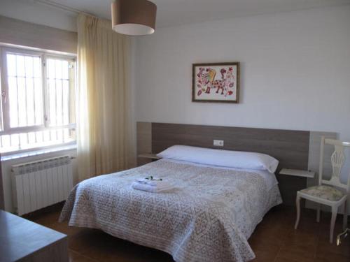 a bedroom with a bed and a table and a window at Casa Peña Sierra de Francia in Aldeanueva de la Sierra