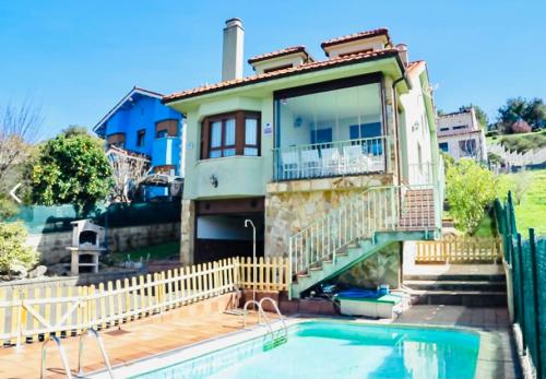 une maison avec une piscine en face d'une maison dans l'établissement Casa Villa Mey, à Candás