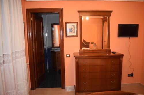a bathroom with a dresser and a mirror and a television at Casa Villa Mey in Candás