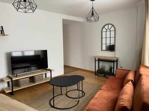 een woonkamer met een bank en een tafel bij Apartamento en palmeira - Colores del Barbanza Naranja in Ribeira