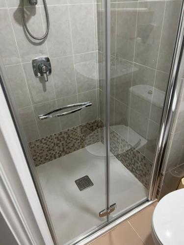 a shower with a glass door in a bathroom at Pensión Zeus in Barakaldo