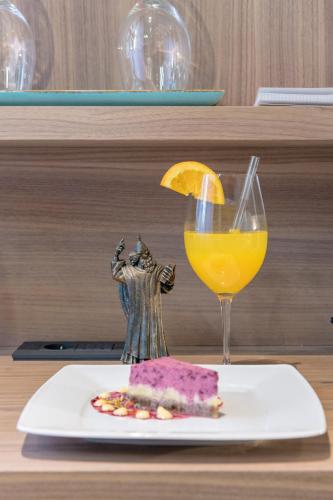 a plate with a slice of cake and a glass of orange juice at Makarun Heritage Rooms in Split