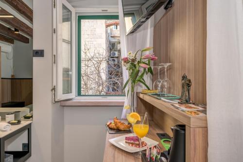 a kitchen with a counter with two glasses of orange juice at Makarun Heritage Rooms in Split