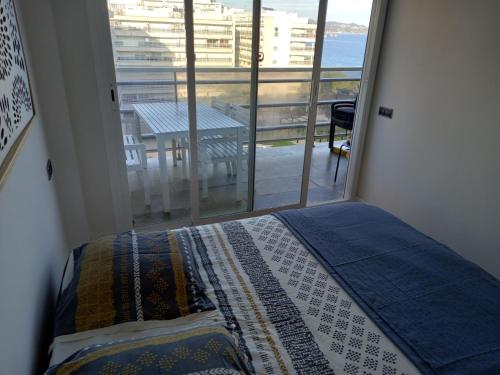 a bedroom with a bed and a view of the ocean at Appart Cosy T3 (Vue Mer et Piscine 4-5 pers) in Blanes